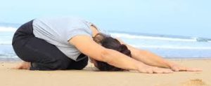 femme sur le sable posture de l'enfant