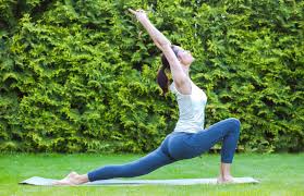 Femme pratique le yoga dans un jardin
