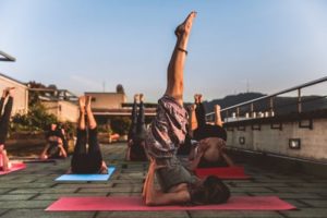 cours collectif de yoga en extérieur posture sarvangasana