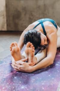 femme yogi en posture de paschimottanasana la pince