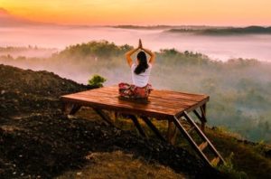 femme pratiquant le yoga face à un paysage au crépuscule