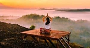 femme pratiquant le yoga devant un paysage au crépuscule