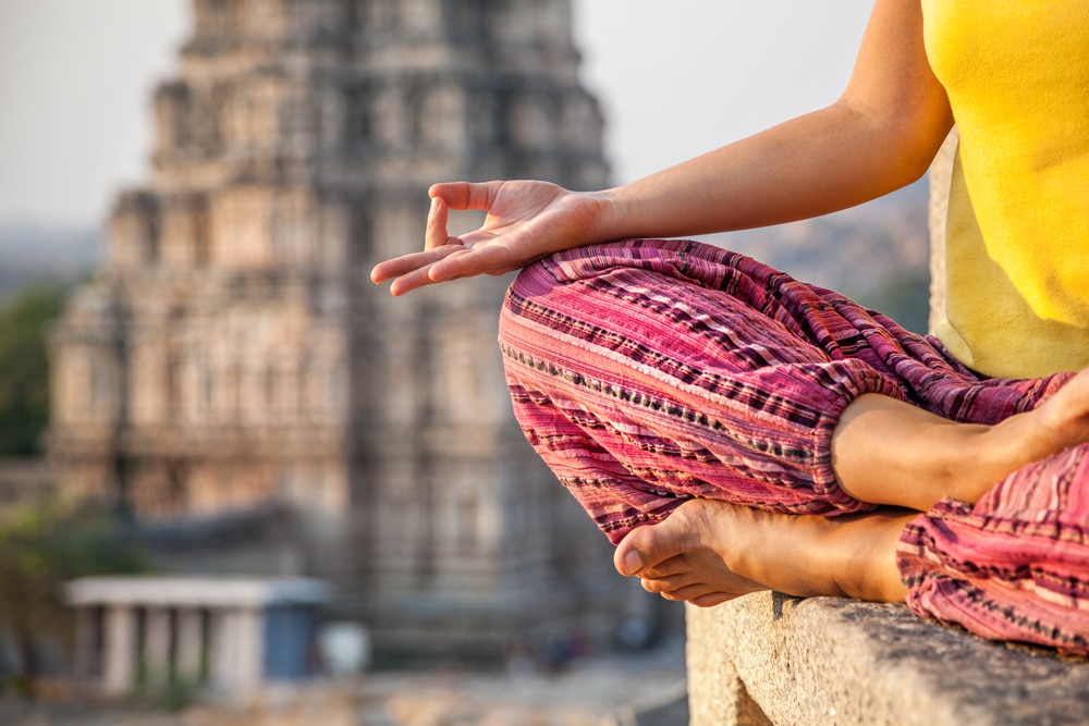 une femme en demi-lotus pratique la méditation en inde