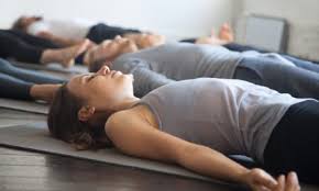 élèves de yoga allongés sur le dos relaxation finale
