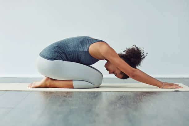 femme en posture de l'enfant bhalasana