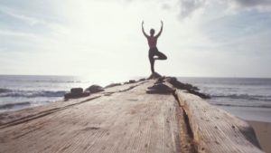 yogi en posture de l'arbre au bord de la mer